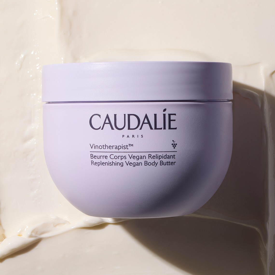 Jar of Caudalie Paris hydrating cream on a creamy background, with soft shadows creating a minimalist and elegant presentation.