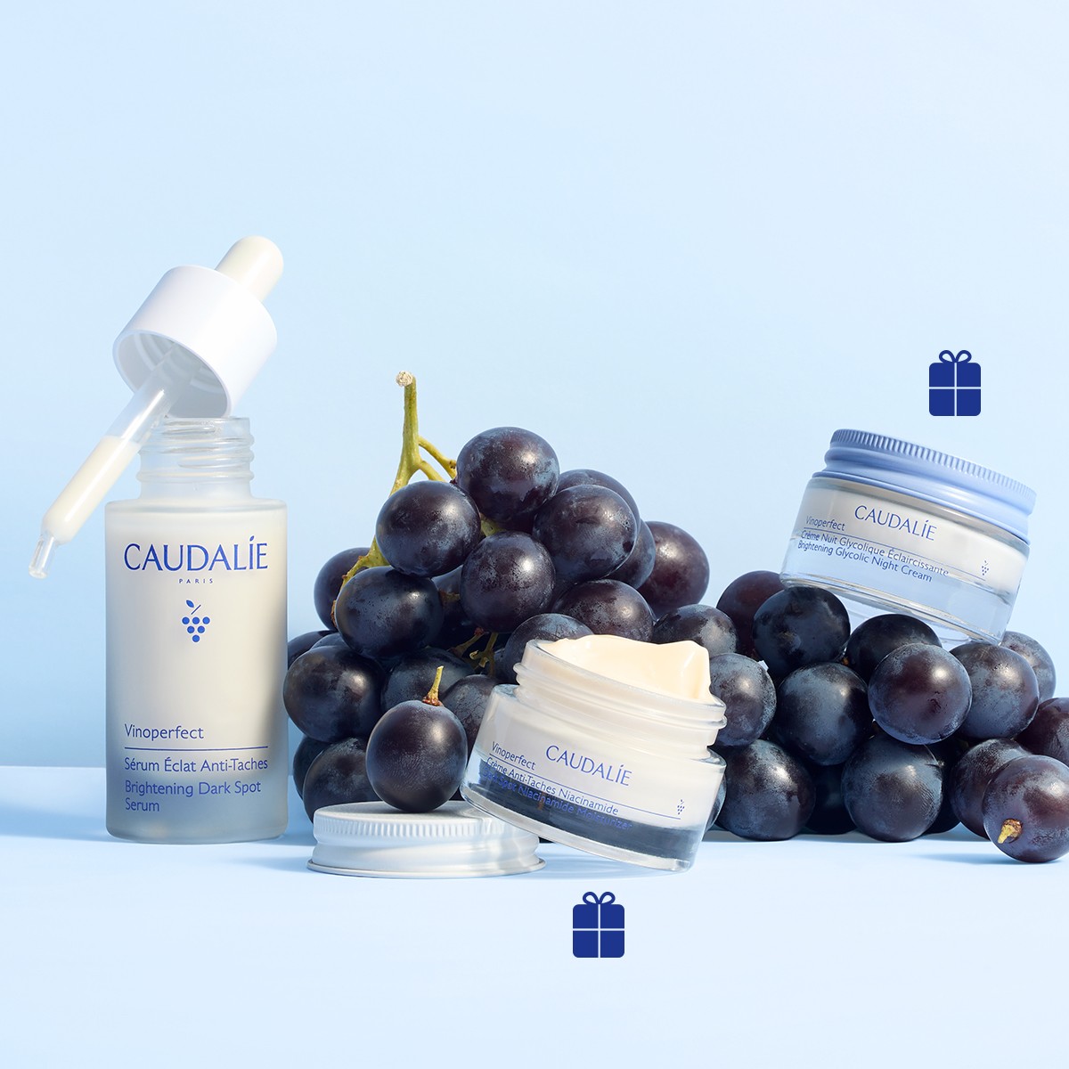 Caudalie skincare products displayed with dark grapes and gift icons on a light blue background.