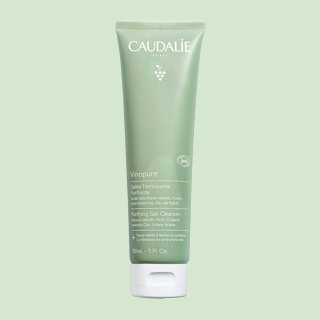A green tube of Caudalie Vinopure Purifying Gel Cleanser standing upright on a light green background.